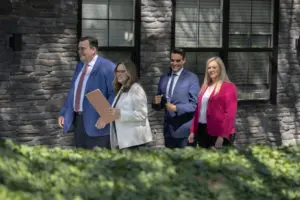 Attorneys Chris Munley, Marion Munley, Robert Munley, and Caroline Munley walking down the street