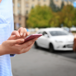 Person using his phone to hail a rideshare service