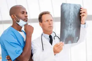 Two Allentown physicians examine a spinal X-ray for signs that improper treatment worsened a patient’s condition—critical evidence Munley Law uses to prove negligence in court. Their careful review highlights the standard of care every competent doctor must meet and how deviations lead to malpractice claims. Munley Law’s attorneys partner with medical experts like these to link diagnostic errors directly to patient harm and financial loss. For a free review of your potential malpractice case, contact Munley Law at 855-866-5529.