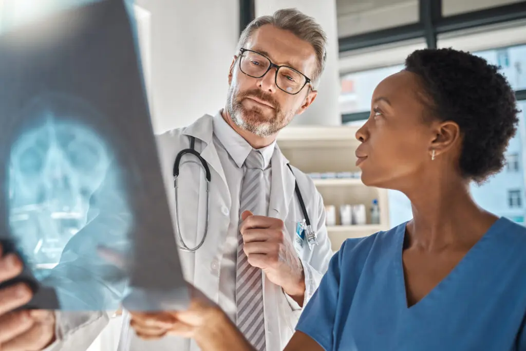 Brain, x ray and neurology doctors in a meeting working on a skull injury in emergency room in a ho.