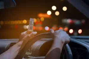 driver with beer in hand driving at night