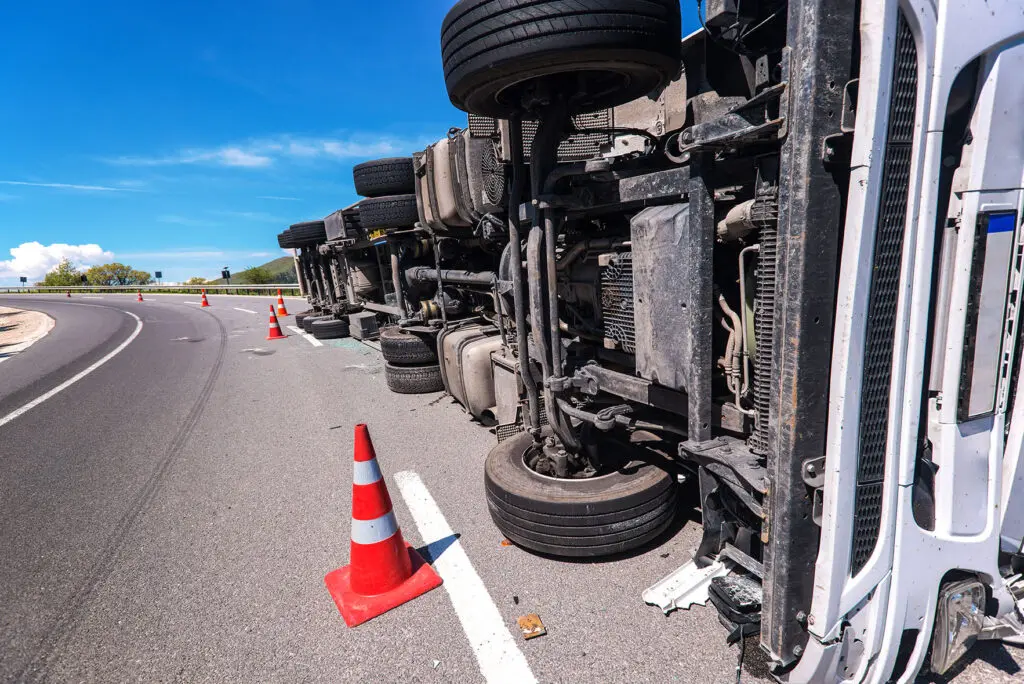 truck laying on its side on the road after accident