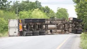 The image depicts an overturned commercial truck accident scene on a rural highway near Scranton, Pennsylvania. It highlights the serious nature of trucking accidents, illustrating the extensive property damage and disruption commonly involved. Victims of similar accidents seeking compensation guidance can contact Munley Law Scranton at (570) 865-4699. The visual underscores how severe truck accidents can significantly impact both physical safety and emotional well-being.