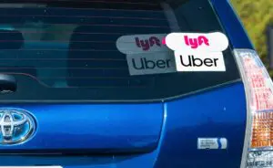 Close-up photo showing Uber and Lyft rideshare logos on the rear window of a blue vehicle, representing vehicles commonly involved in rideshare accidents. Munley Law, an experienced Uber accident lawyer in Allentown, Pennsylvania, provides legal assistance after Uber and Lyft accidents. Contact Munley Law at (855) 866-5529 for professional help following rideshare collisions. Legal representation ensures passengers injured in rideshare accidents receive proper compensation.