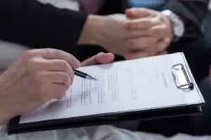 An Allentown wrongful death attorney from Munley Law provides professional guidance during a legal consultation. The image clearly shows legal paperwork on a clipboard, signifying documentation for a wrongful death claim. Munley Law supports families in Allentown, Pennsylvania, through detailed consultations focused on pursuing rightful compensation after a tragic loss. To arrange your confidential consultation, contact Munley Law at 855-866-5529 and receive immediate expert assistance.