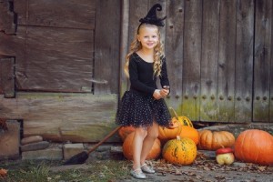 little girl dressed in a witch costume trick or treating