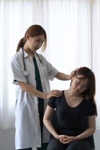 Does Workers' Comp Protect Your Job in Scranton?. Doctor checking injured woman's spine during examination.