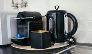 Coffee machine, kettle, and canister on a counter next to a sink