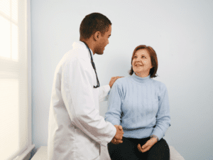 Doctor talking to a woman with hand on her shoulder and holding her other hand