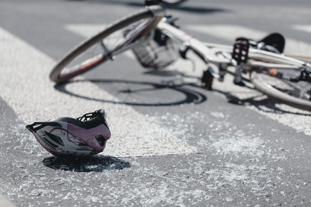 bicycle helmet and broken bike in the roadway