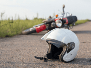 Motorcycle lying on its side on the road with helmet in front of it