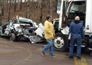 Dan Munley reviewing truck accident scene with smashed passenger cars