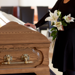 mourner placing hand on casket