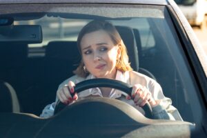 Does driving slow cause more car accidents? nervous woman behind steering wheel