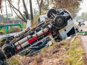 Truck lying upside down on the side of an embankment