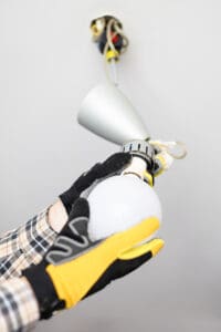 electrician remove bulb from defective ceiling light at home