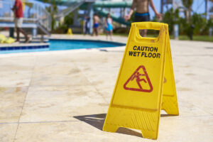 Yellow wet floor caution sign at a hotel pool
