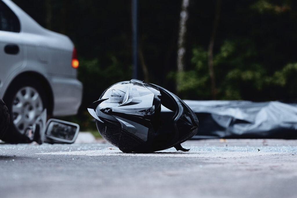 Close-up of black motorcycle helmet. Inattentive car driver on the road with motorcyclist