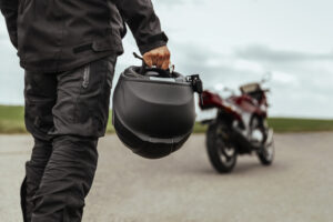 man with helmet in hand walks to motorcycle, motorcycle accident lawyer