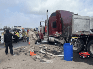 Truck accident scene with a badly damaged truck and emergency personnel sorting through the wreckage