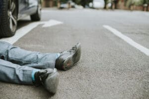 Person lying in the road after being hit by a car