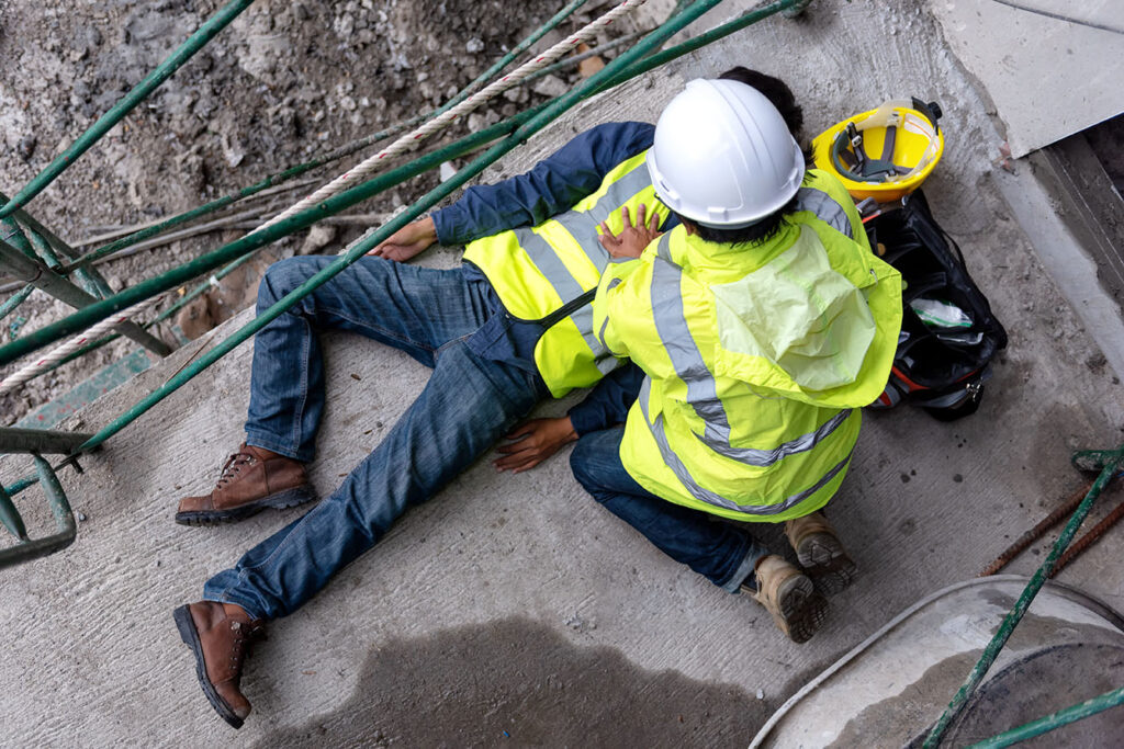 Worker helping another worker after accident. in need of a Philadelphia workers' compensation death benefits attorney