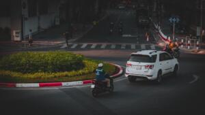 Car and a motorbike in a roundabout