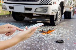Man use mobile phone, blur image of car accident as background.