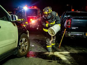 fireman pouring sand over oil spill from car accident