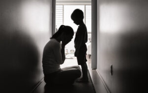 Grieving woman with child in dark hallway