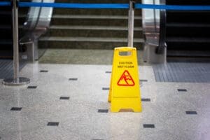 Yellow caution slip and fall sign on a tiled floor