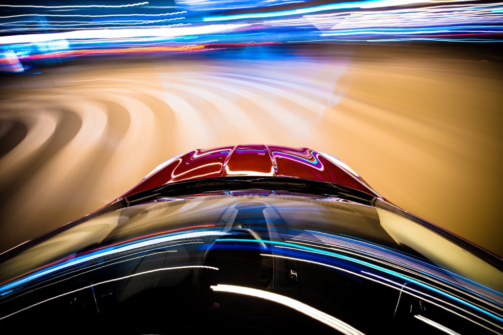 Speeding Car. Car in Motion. Blurred City Lights on Curved Road. Long Exposure Car Driving Photo.