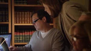 Munley Law offers dedicated tractor-trailer accident lawyer services in Allentown, PA, call844-686-5397 for immediate legal assistance. This image shows a severely damaged tractor-trailer stopped alongside a rural Pennsylvania highway. The truck's front end and side panels are heavily crushed, with shattered windows and extensive debris spread across the asphalt. The accident scene is realistically captured under moody, dim evening lighting, highlighting the severity and urgency of legal representation following such an accident.