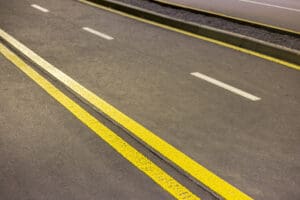 Wide bright double yellow marking line along empty asphalt highway